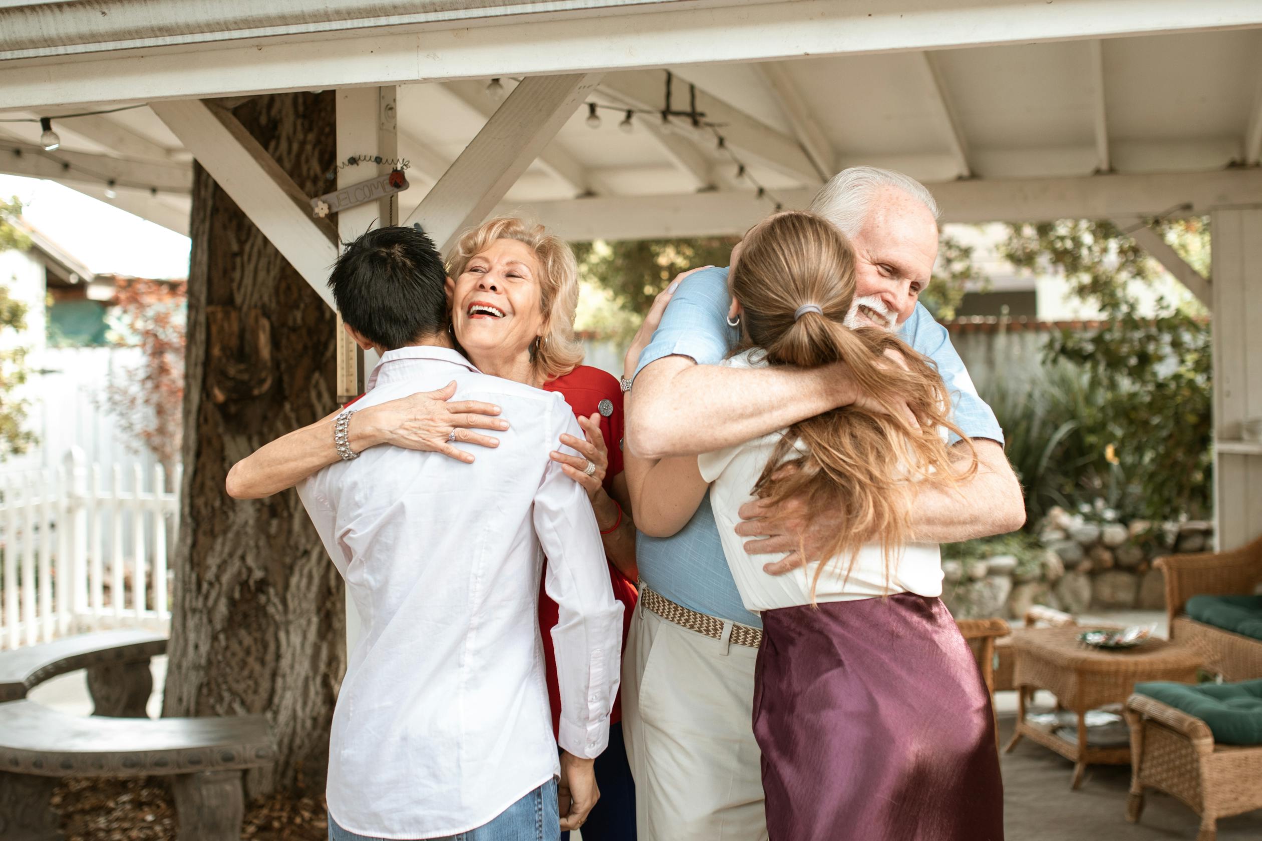 Mehrgenerationale Familie umarmt sich herzlich — die unsichtbare Arbeit, die alles zusammenhält